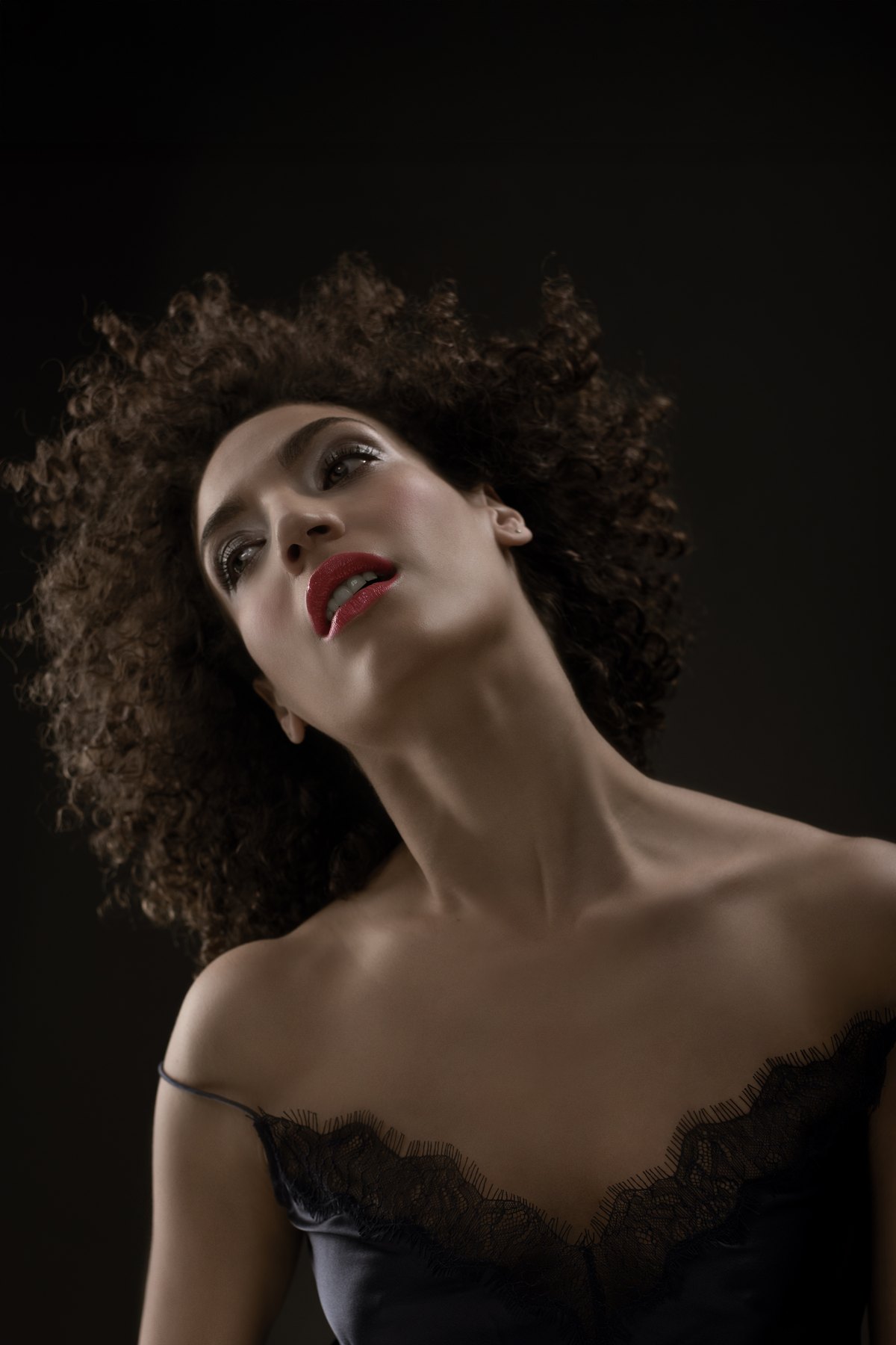 Low-Key-Portrait einer Frau mit Locken in schwarzer Spitze — Das Studiozwei, Werbefotograf München