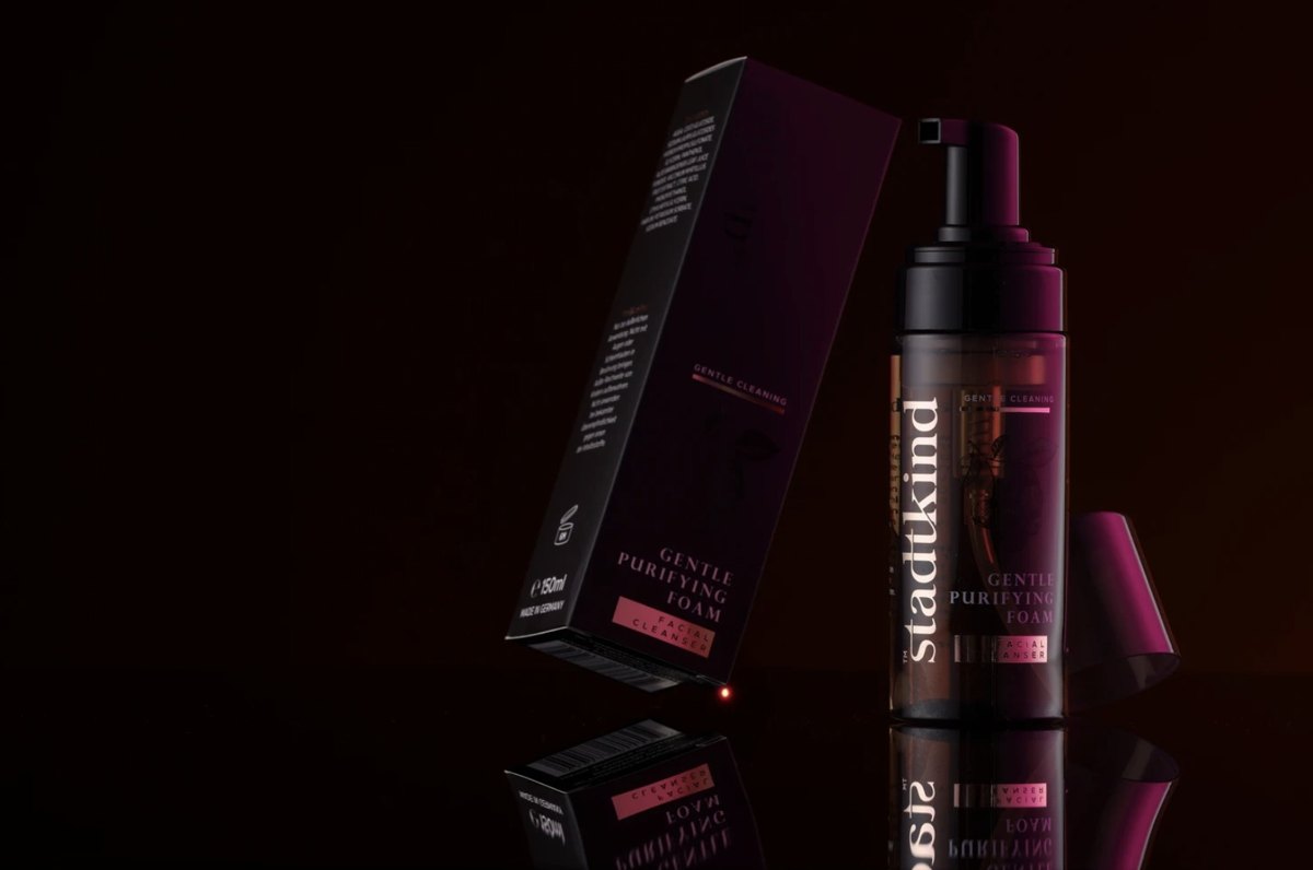 Stadtkind Gentle Purifying Foam Pumpflasche neben ihrer Verpackung auf spiegelnder Flaeche vor dunklem Hintergrund — Das Studiozwei, Werbefotograf München