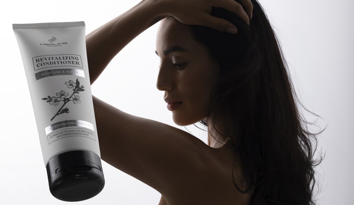 Frau im Profil mit erhobenem Arm, davor eine helle Revitalizing Conditioner Tube — Das Studiozwei, Werbefotograf München