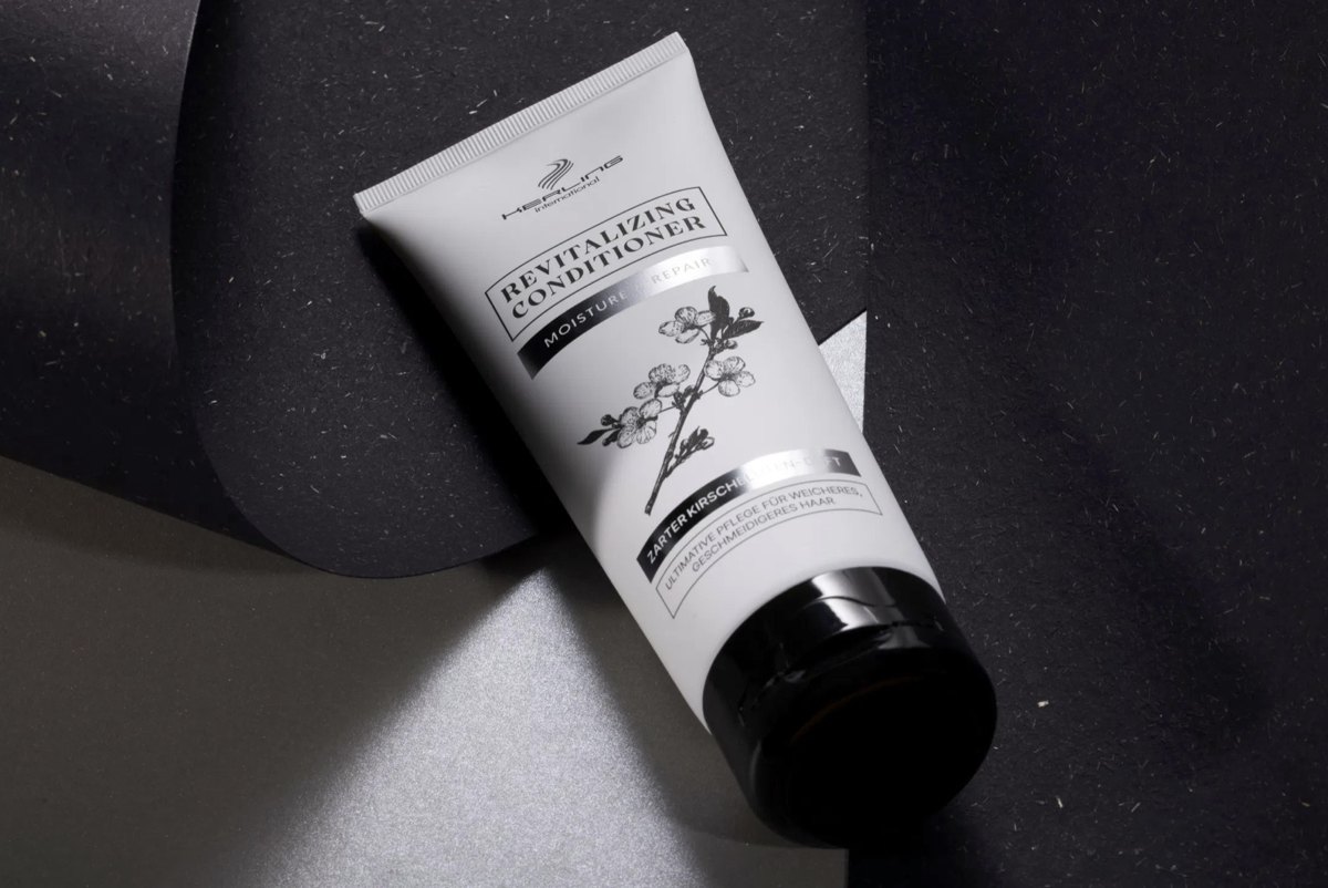 Helle Revitalizing Conditioner Tube liegt zwischen schwarzem und silbernem Papier — Das Studiozwei, Werbefotograf München