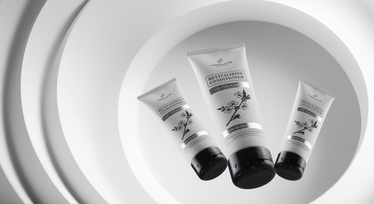 Drei helle Revitalizing Conditioner Tuben schweben vor konzentrischen weissen Ringen — Das Studiozwei, Werbefotograf München