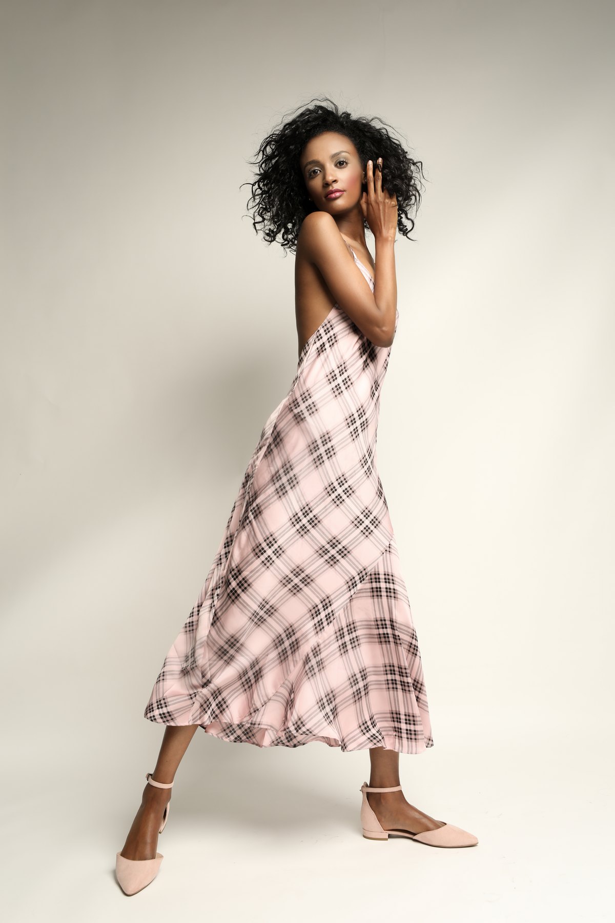 Model im karierten Sommerkleid in Bewegung vor hellem Hintergrund — Das Studiozwei, Werbefotograf München
