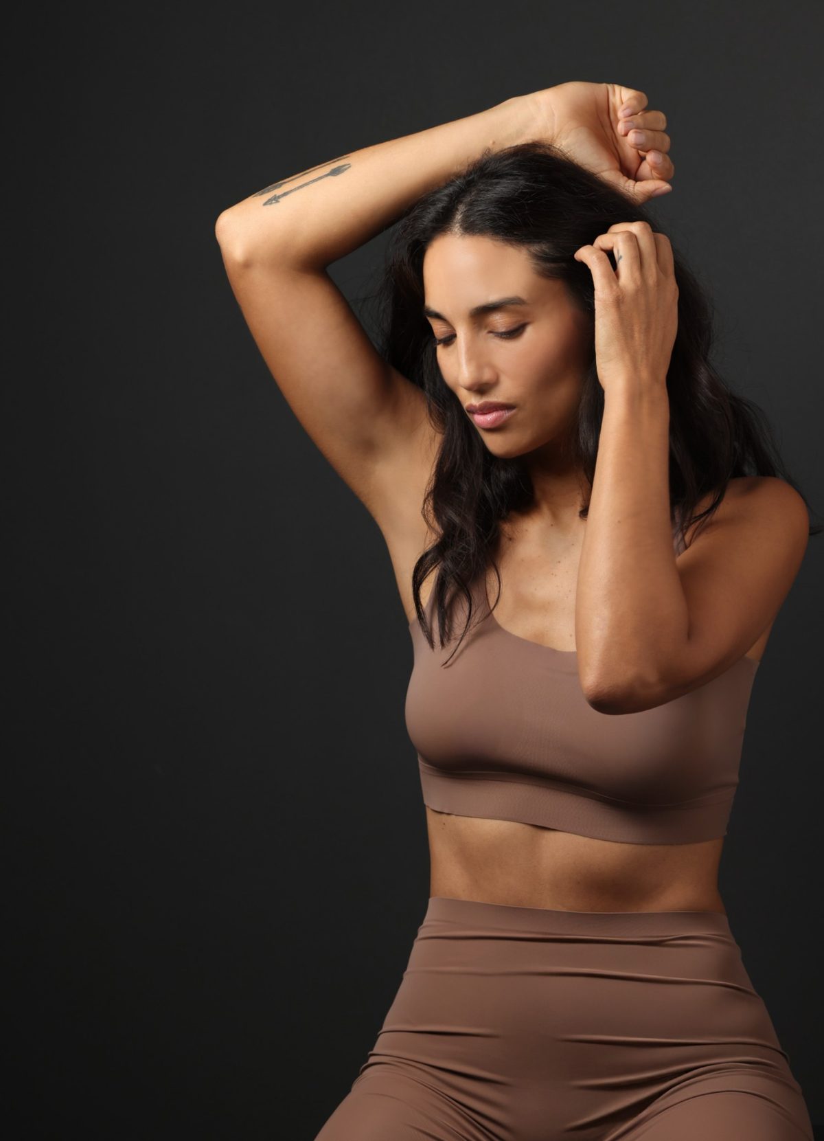 Model in nudefarbenem Sport-Set aus Bustier und Leggings vor dunkelgrauem Studiohintergrund — Das Studiozwei, Werbefotograf München