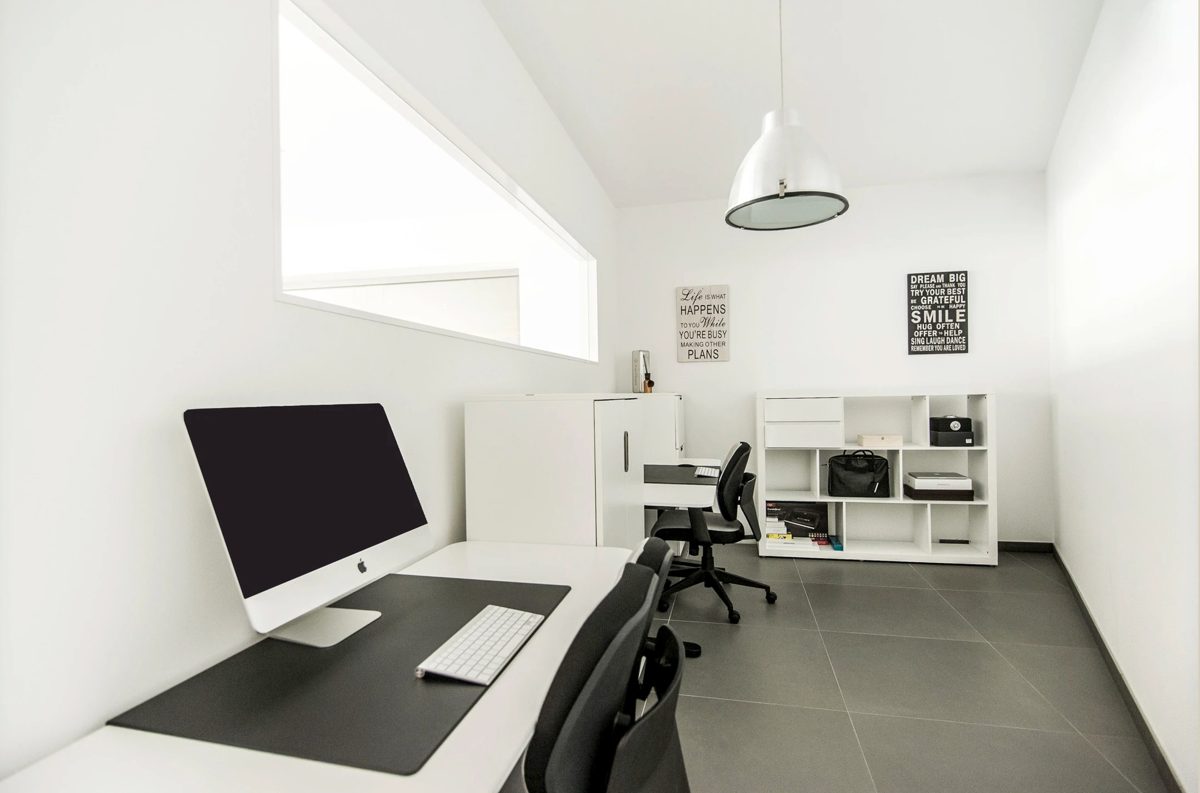 Kleines weisses Buero mit Schreibtisch, Monitor, Drehstuehlen und Regal — Das Studiozwei, Werbefotograf München