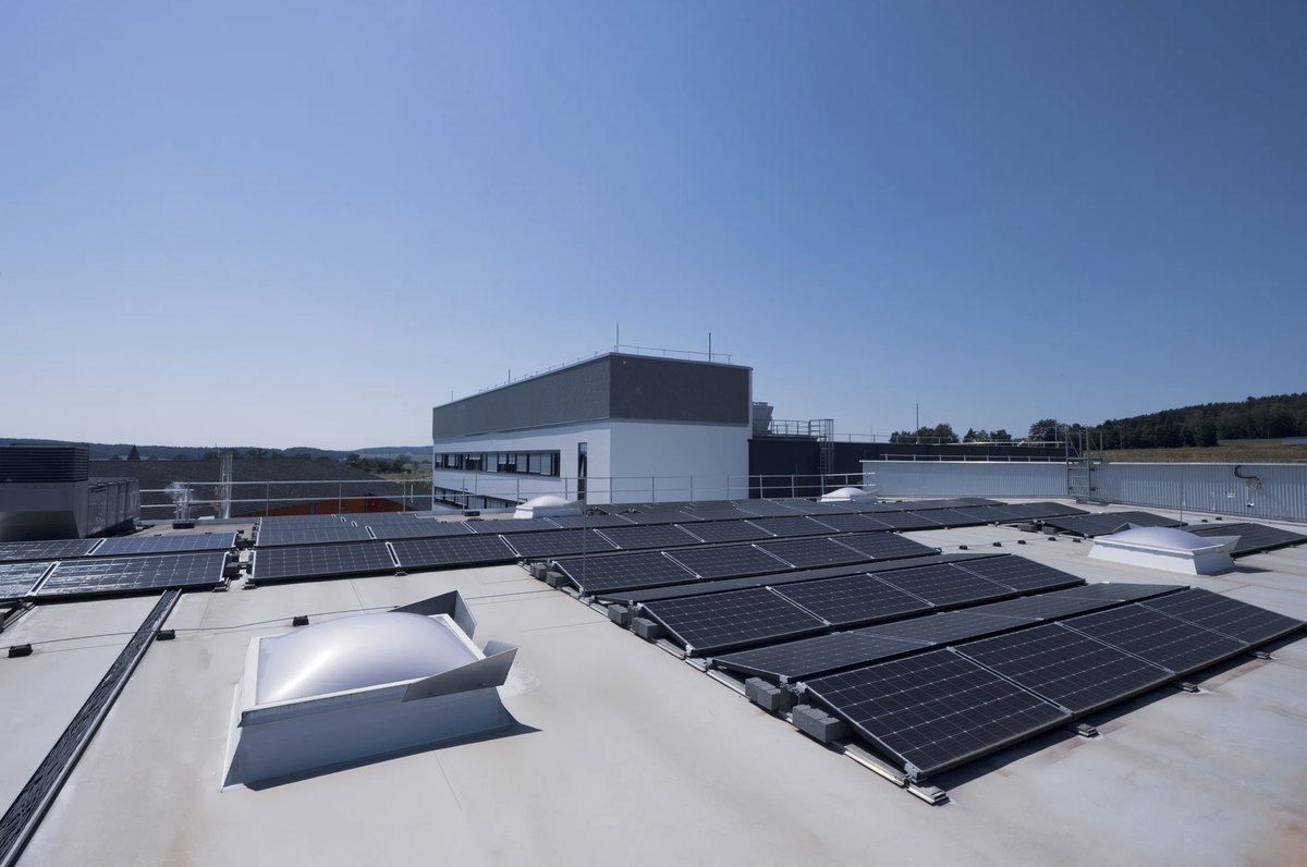 Flachdach mit Photovoltaikreihen und Oberlichtern ueber einem Gewerbebau — Das Studiozwei, Werbefotograf München