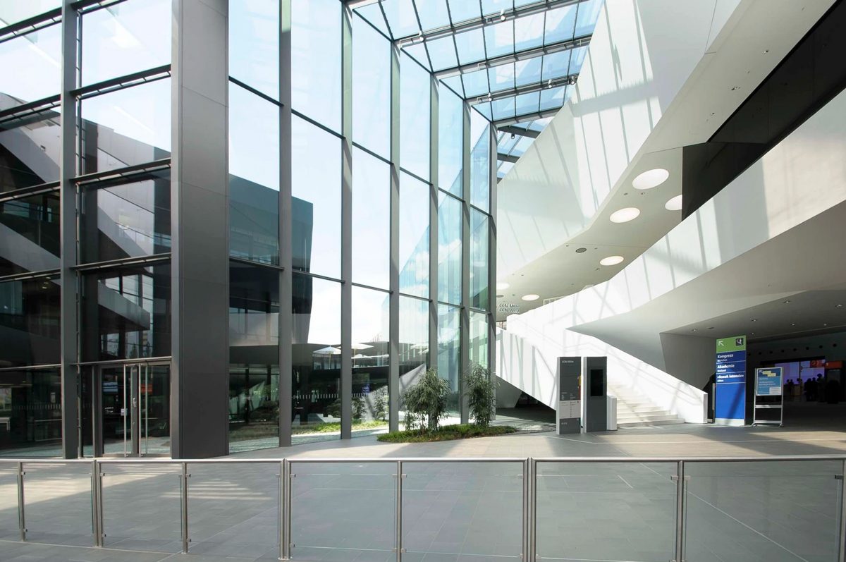 Foyer mit hoher Glasfassade und geschwungener Lichtdecke mit Blick nach draussen — Das Studiozwei, Werbefotograf München