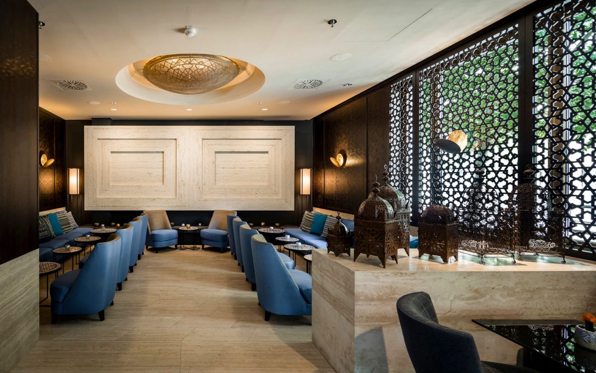 Hotellounge mit blauen Sesseln, ornamentalen Gitterwaenden und goldener Deckenrosette — Das Studiozwei, Werbefotograf München