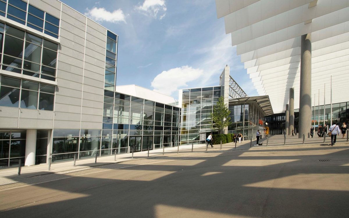 Moderne Messegebaeude mit Glasfassade und weissem Vordach unter blauem Himmel — Das Studiozwei, Werbefotograf München