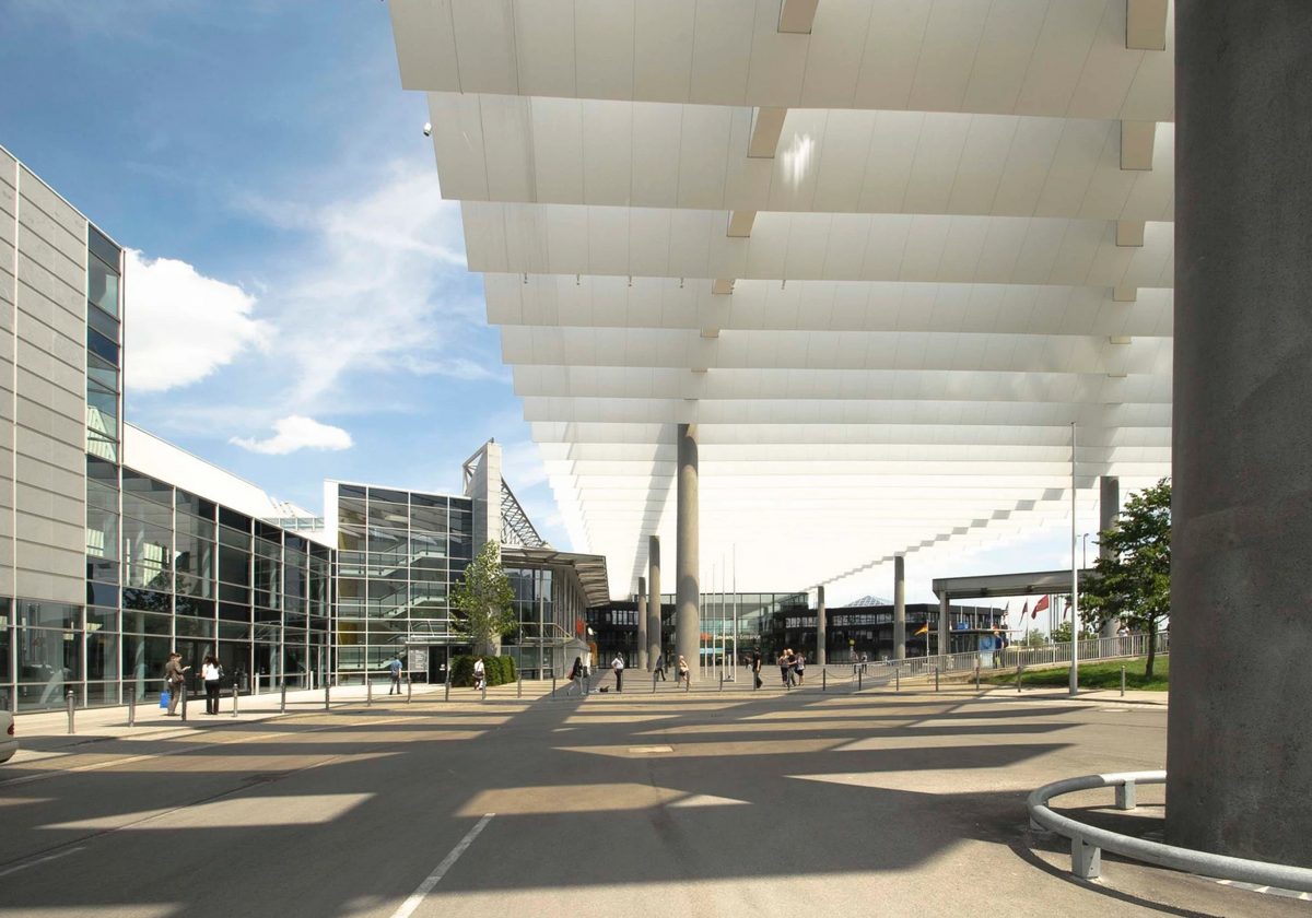 Ueberdachte Messepromenade mit weissen Dachlamellen und Glasfassade in Fluchtperspektive — Das Studiozwei, Werbefotograf München