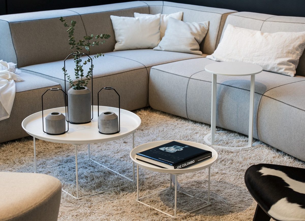 Graues Modulsofa mit runden Beistelltischen und Hochflorteppich in heller Wohnlounge — Das Studiozwei, Werbefotograf München