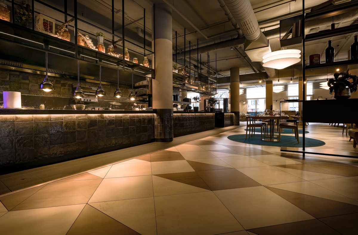 Offene Kuechentheke mit dunkler Kachelfront und Haengeleuchten in einem Restaurant — Das Studiozwei, Werbefotograf München