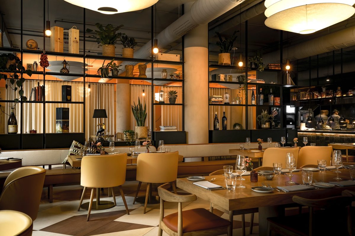 Restaurantbereich mit gelben Polsterstuehlen, Holztischen und warmen Kugelleuchten — Das Studiozwei, Werbefotograf München