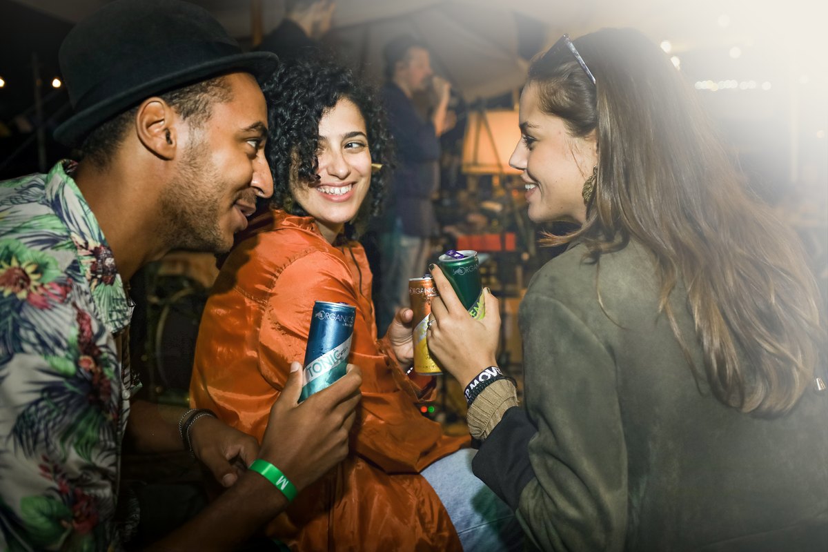 Drei junge Menschen im Gespraech an der Bar mit Getraenkedose — Das Studiozwei, Werbefotograf München