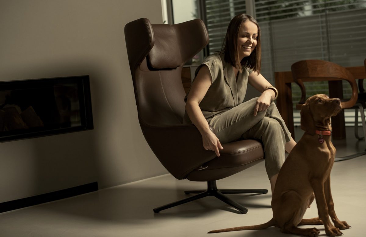 Lifestyleportrait einer Frau im Sessel mit ihrem Hund in einem modernen Wohnraum — Das Studiozwei, Werbefotograf München