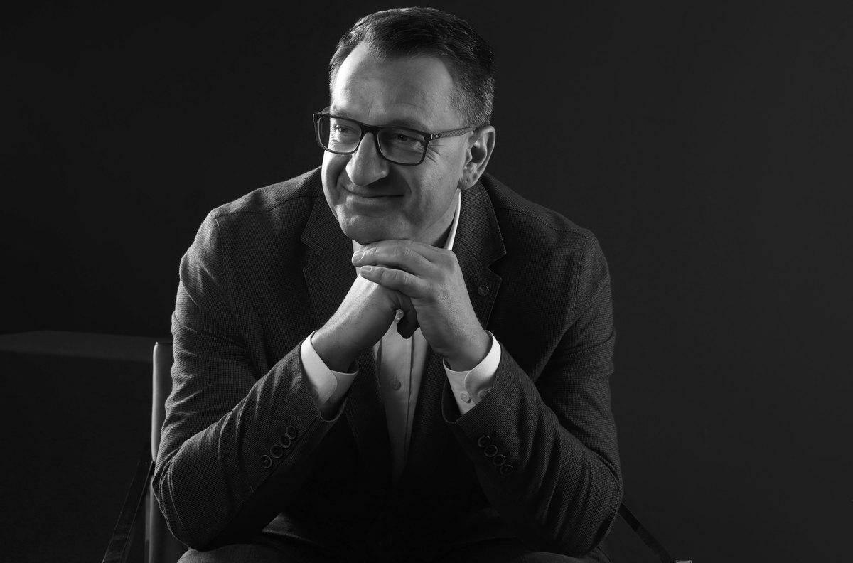 Schwarzweisses Portrait eines Mannes mit Brille, Kinn aufgestuetzt — Das Studiozwei, Werbefotograf München