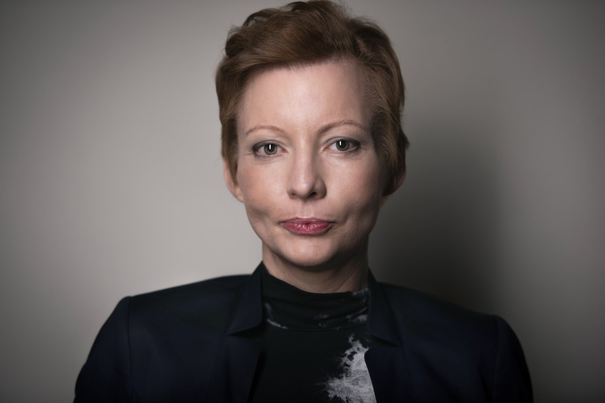 Portrait einer Frau im dunklen Blazer vor grauem Hintergrund — Das Studiozwei, Werbefotograf München