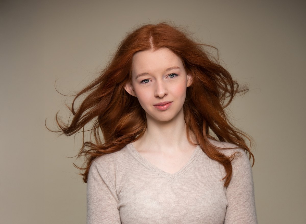 Portrait einer jungen Frau mit langen roten Haaren vor Beige — Das Studiozwei, Werbefotograf München