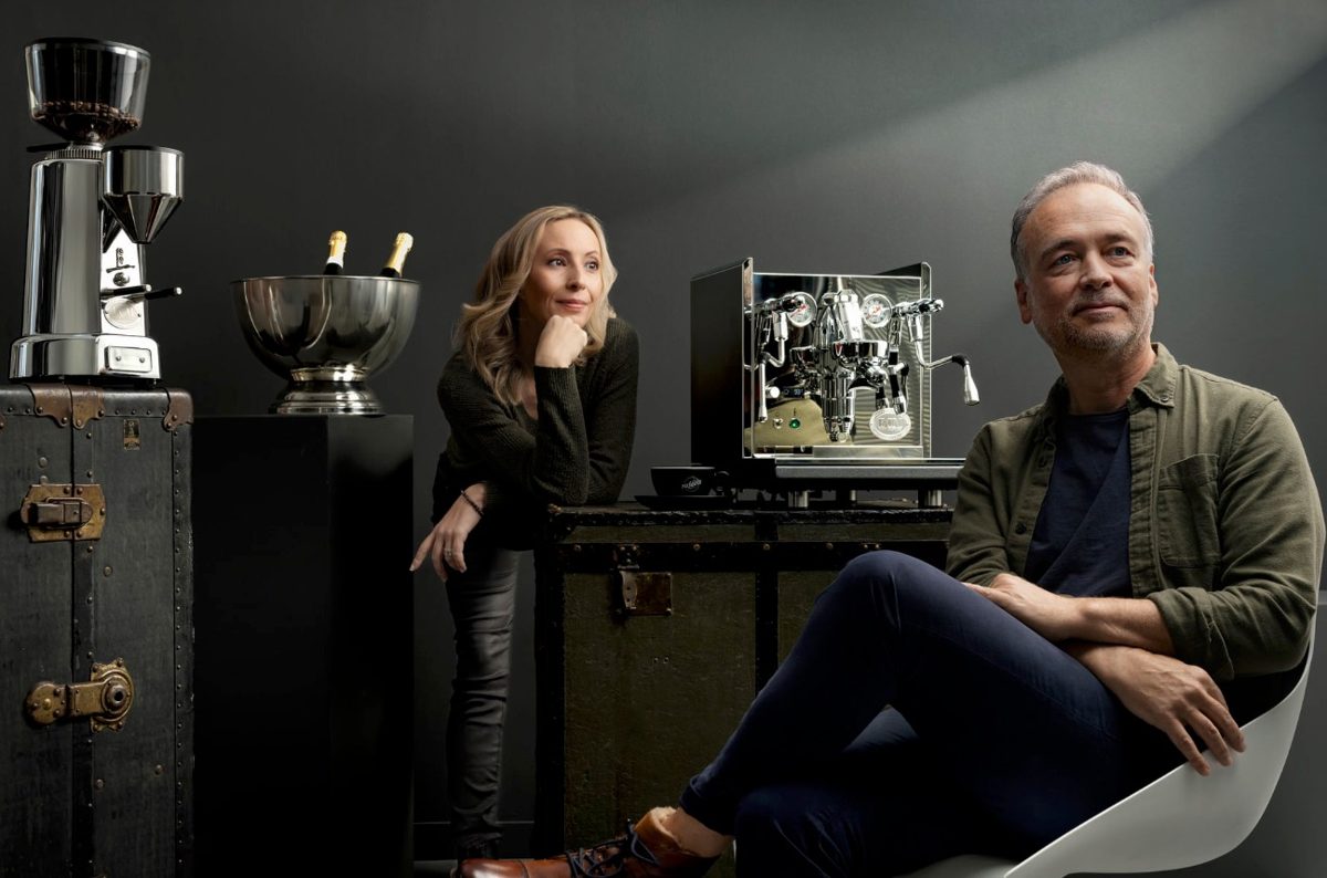 Doppelportrait einer Frau und eines Mannes mit Siebtraegermaschine und Kaffeemuehle vor dunklem Studiohintergrund — Das Studiozwei, Werbefotograf München
