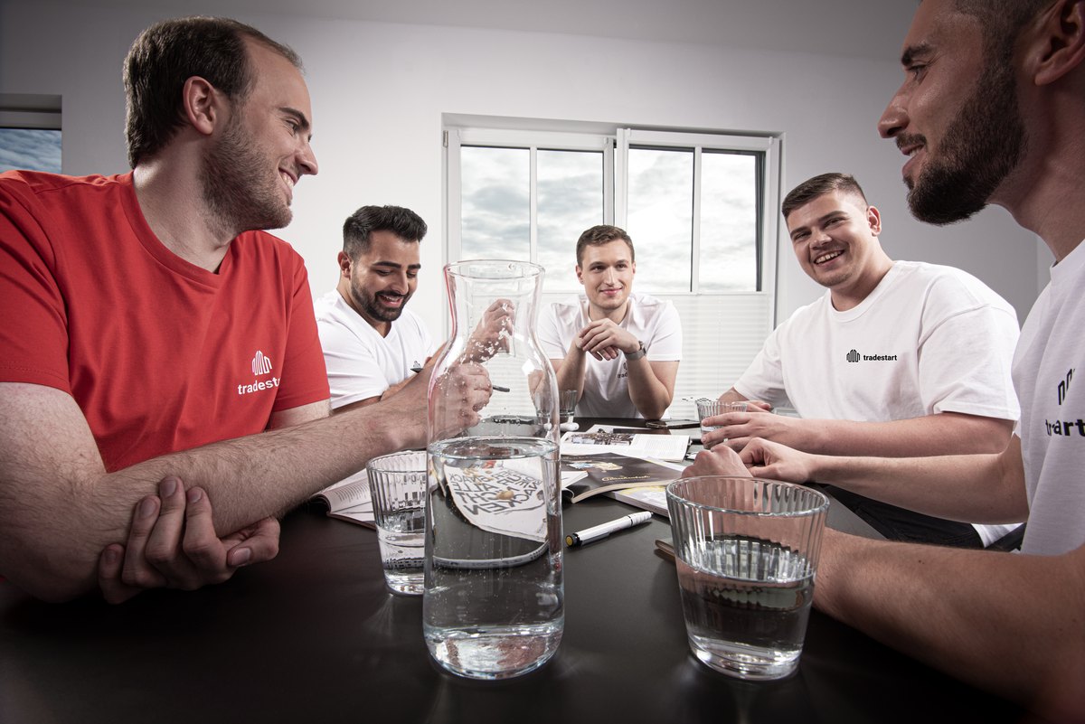 Mitarbeiter in Arbeitskleidung im Gespraech am Tisch — Das Studiozwei, Werbefotograf München