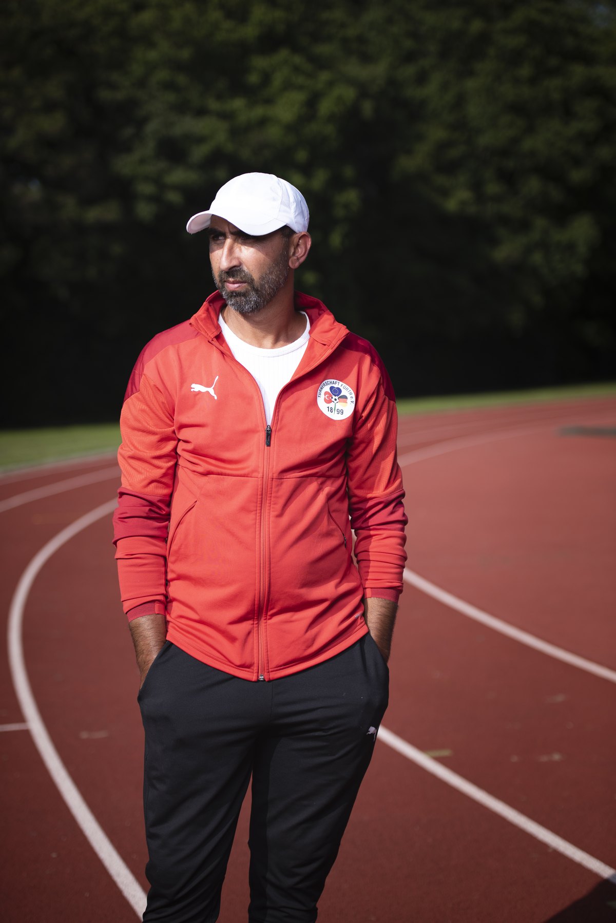 Trainer in roter Jacke auf einer roten Laufbahn — Das Studiozwei, Werbefotograf München