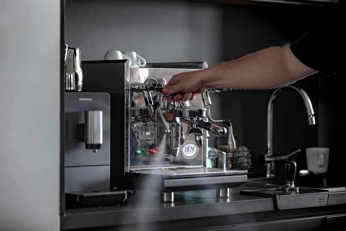 Hand bedient professionelle Espressomaschine mit aufsteigendem Dampf — Das Studiozwei, Werbefotograf München