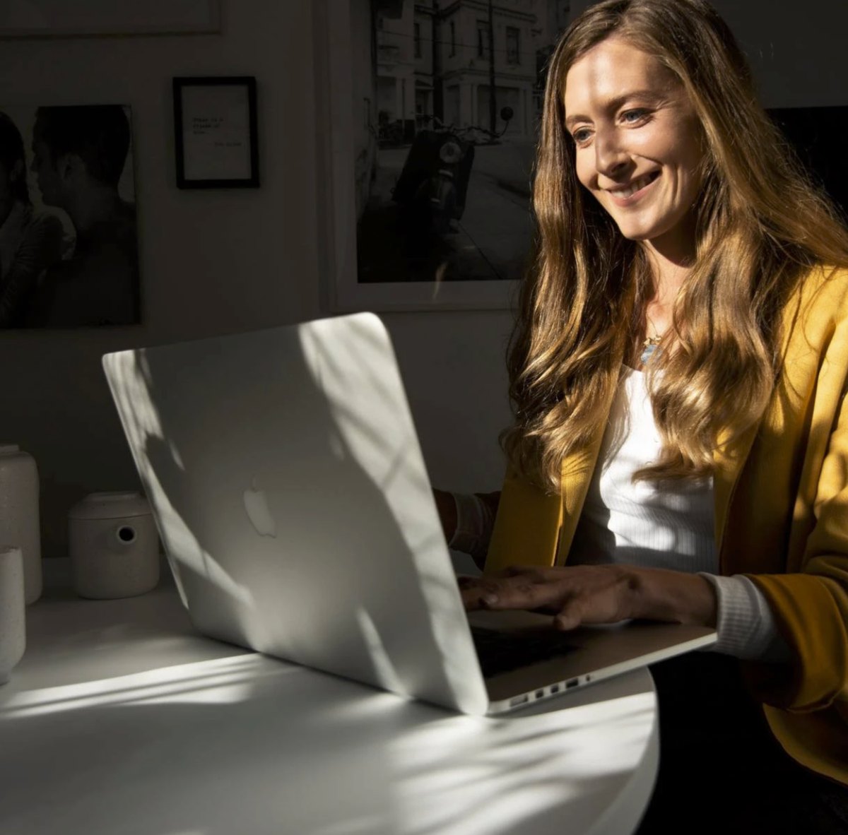 Frau am Laptop im warmen Gegenlicht eines Buerofensters — Das Studiozwei, Werbefotograf München