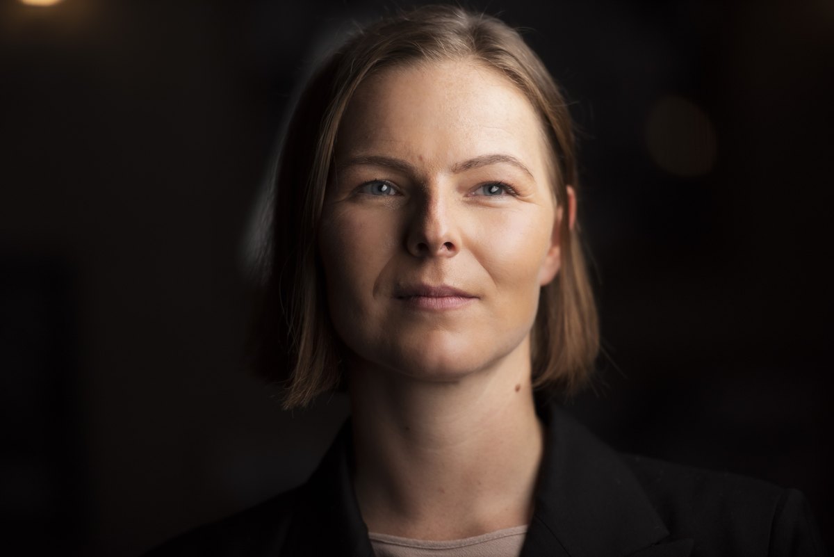Frau im dunklen Blazer im warmen Low-Key-Licht — Das Studiozwei, Werbefotograf München