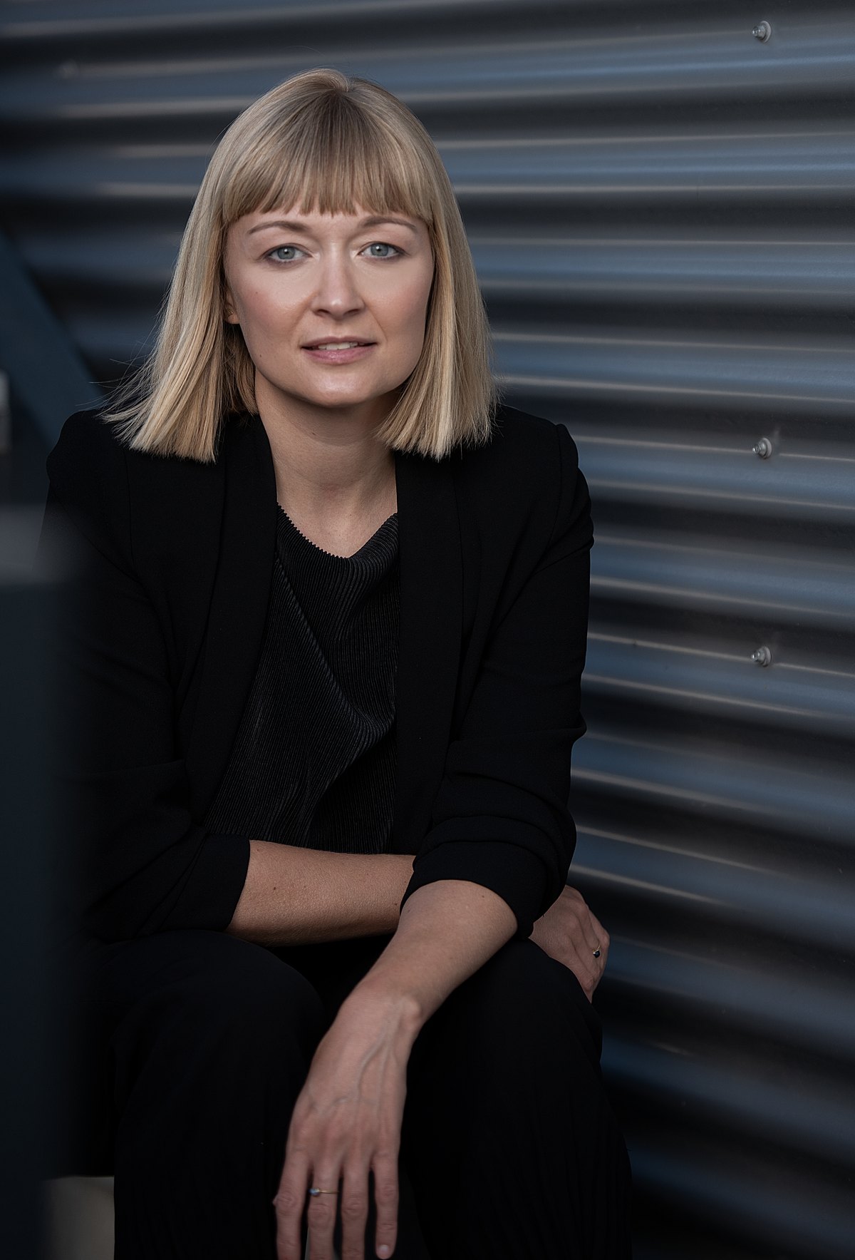 Portrait einer Frau in Schwarz vor gewellter Metallwand — Das Studiozwei, Werbefotograf München