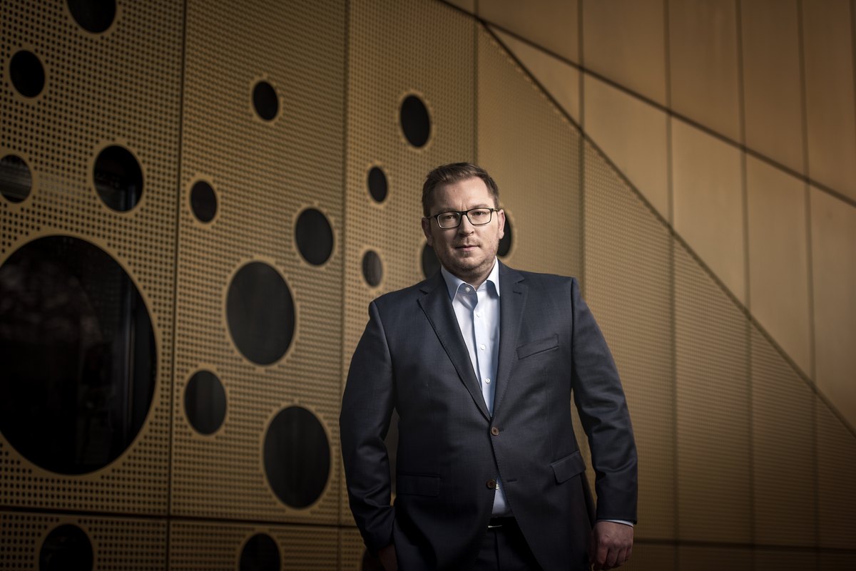Mann im Anzug vor goldfarbener perforierter Wand — Das Studiozwei, Werbefotograf München