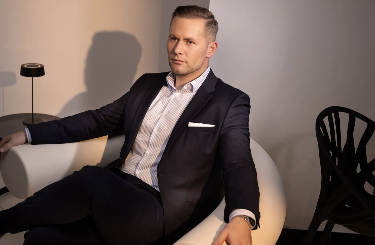 Mann im Anzug mit Einstecktuch auf hellem Sofa — Das Studiozwei, Werbefotograf München