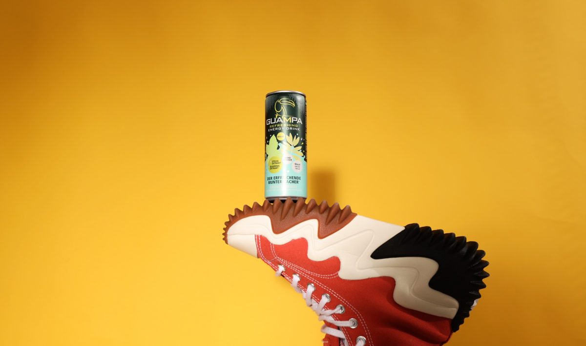 Getraenkedose balanciert auf einer Sneakersohle vor gelbem Hintergrund — Das Studiozwei, Werbefotograf München