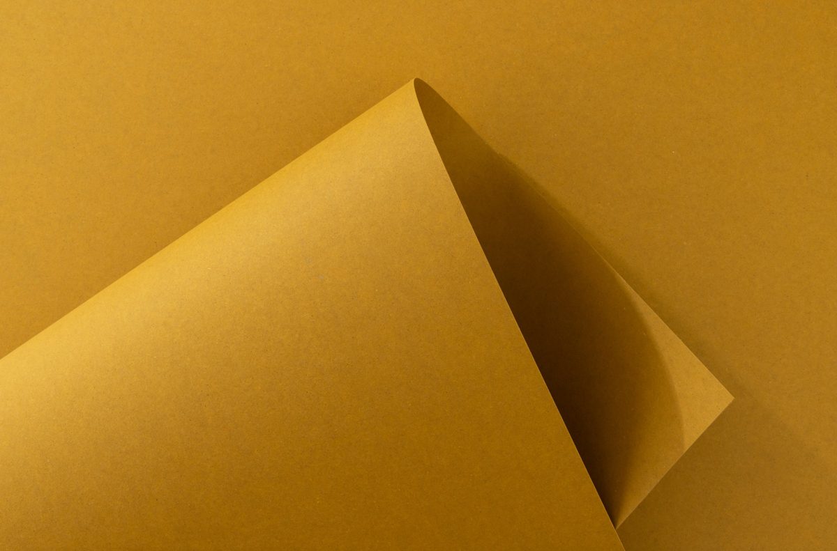 Gerollter ockerfarbener Papierbogen als grafisches Stillleben im Streiflicht — Das Studiozwei, Werbefotograf München